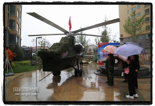 小區(qū)突然出現(xiàn)“飛機(jī)坦克”，其中殲15艦載戰(zhàn)斗機(jī)一架、99式主戰(zhàn)坦克一輛、武直-10武裝直升機(jī)一架，吸引了眾多市民雨中圍觀、合影。